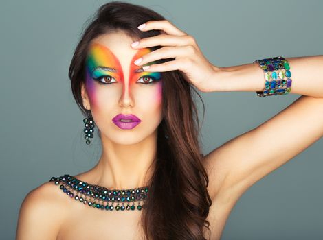Portrait of a young beautiful girl with a fashion bright multicolored makeup of eyes