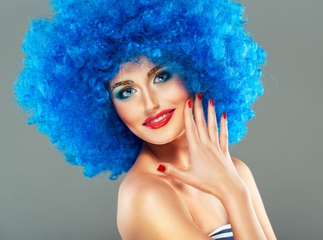 Portrait of a young beautiful girl with bright makeup, red lips in blue wig