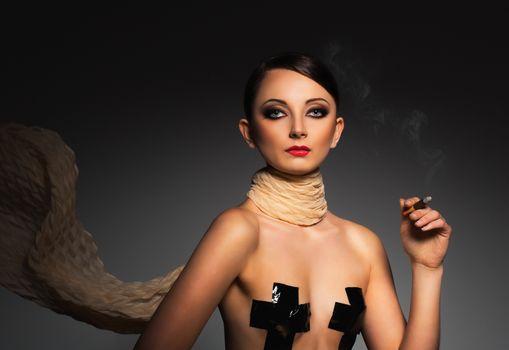Portrait of a beautiful young woman with cigar and with a glamorous retro makeup