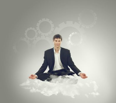 Businessman sitting in lotus position on a cloud and think mechanical thoughts