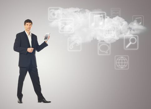 Businessman with tablet and the cloud with applications icons on grey background