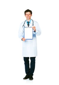 Full length young smiling male doctor showing clipboard with copy space for text on white background