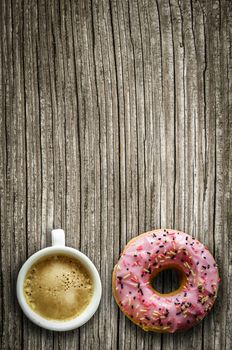 Retro Filtered Image Of A Pink Donut And A Cup Of Coffee On A Rustic Wooden Table With Copy Space