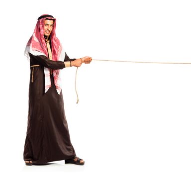 Young Arab pulling a rope isolated on white background