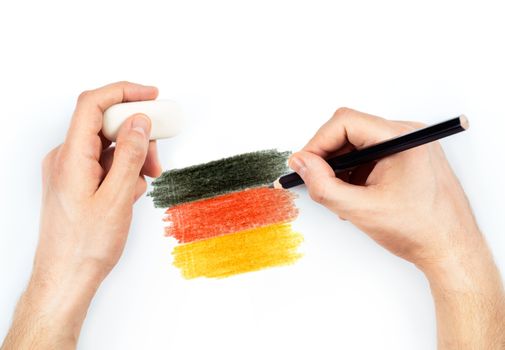 Man's hands with pencil draws flag of Germany on white background