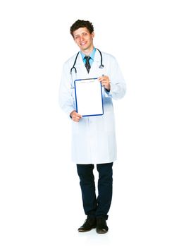 Full length young smiling male doctor showing clipboard with copy space for text on white background