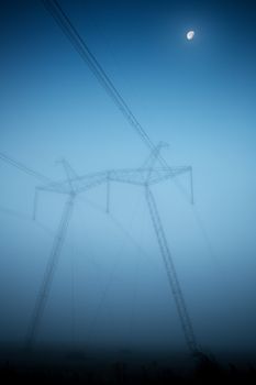 Power lines and pylons in fog in the early morning