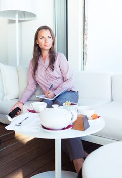 Businesswoman with phone and organizer in a coffee house