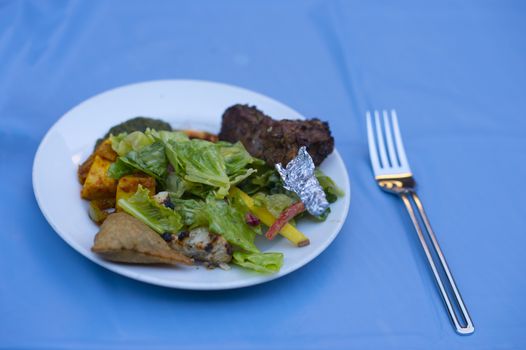 A plate of salad and meat ready to be consumed