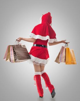 Christmas girl holding shopping bags, rear view portrait isolated.