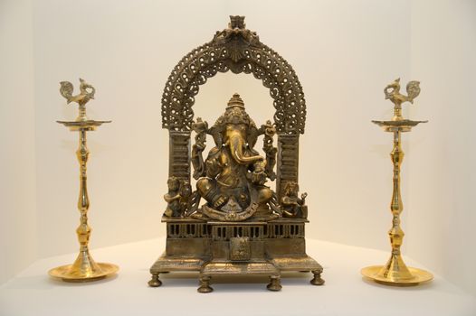 A metal statue of ganesha with musical instruments