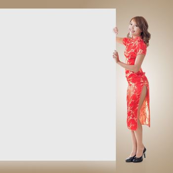 Attractive Chinese woman dress traditional cheongsam and hold blank board, full length portrait.