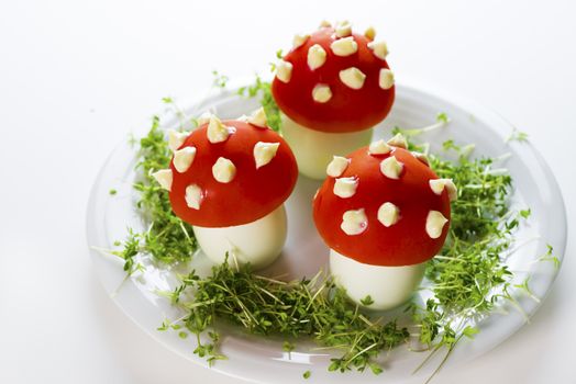 Fly mushroom formed from boiled egg, cover with the tomato mayonnaise. Funny food for children or party.