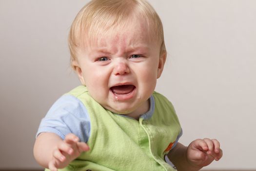 Child with arm stretched out while crying at something