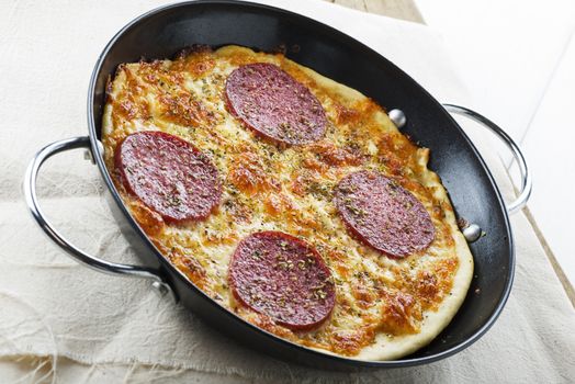 Mini salami pizza in a small pan