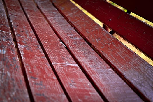 background detail of a wooden benches in the park burgundy color