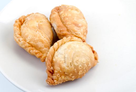 delicious fried Curry Puffs on white dish