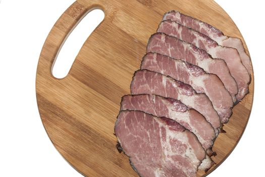 Sliced smoked ham on wooden board on the white background.