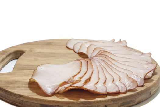 Cutted smoked sirloin on a wooden board on the white background.