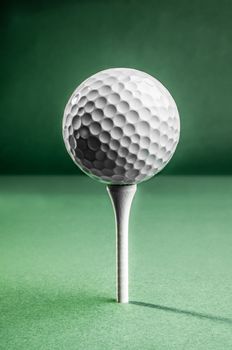 A white golf ball positioned on top of a tee, ready for the tee shot.