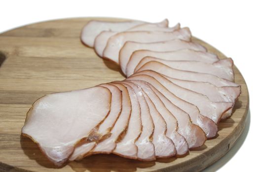 Cutted smoked sirloin on a wooden board on the white background.