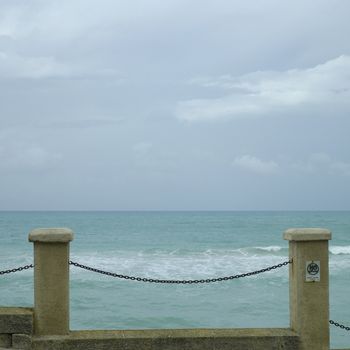 Pillar and chain fence overlooking the tropical ocean