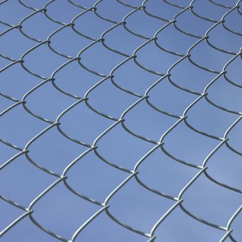 Chain link fence against blue sky