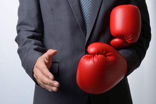Businessman remove red boxing gloves to offer a handshake on white background,compromise concept