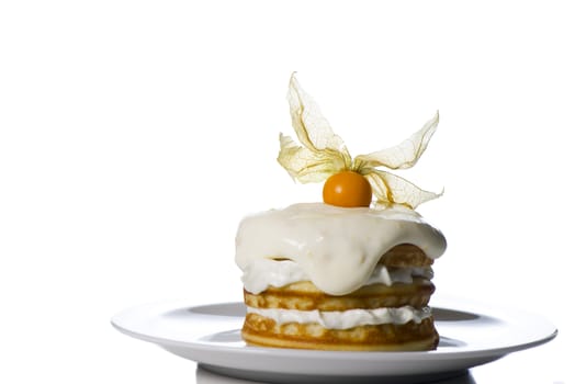 a stack of pancakes with cream and decorated with physalis on white background