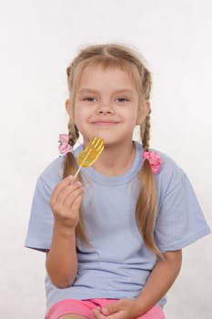 the five-year old girl enthusiastically eats candy