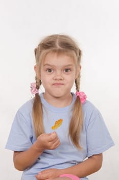 the five-year old girl enthusiastically eats candy