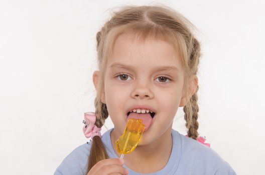 the five-year old girl enthusiastically eats candy