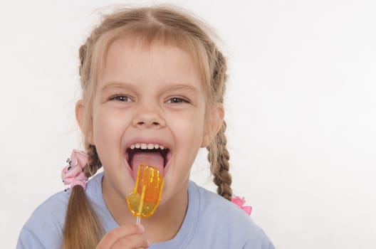 the five-year old girl enthusiastically eats candy