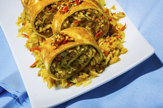 asian curry rice roll cutted as a sushi in a white plate on blue napkin