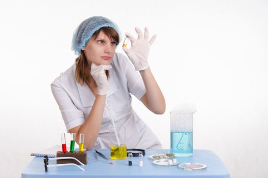 Young beautiful girl posing chemical experiments in the laboratory