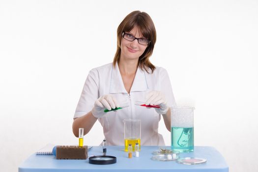 Young beautiful girl posing chemical experiments in the laboratory