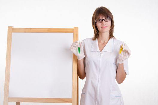 Chemist with test tubes stands at the blackboard with advertising