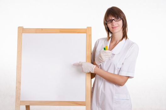 Chemist with test tubes stands at the blackboard with advertising