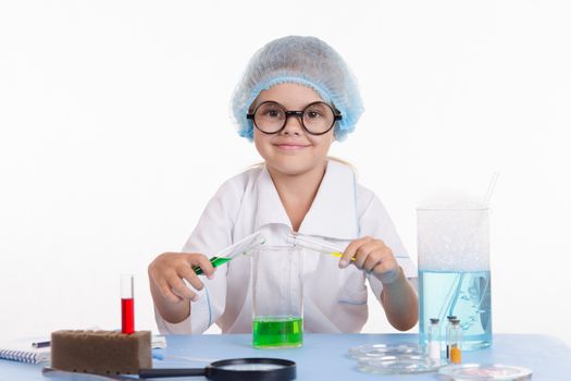 Girl sitting in chemistry class and makes the simplest experiments