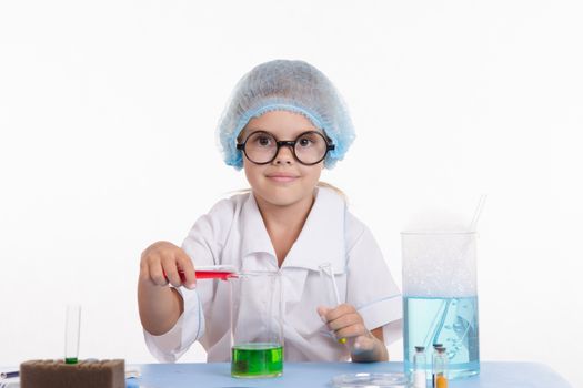 Girl sitting in chemistry class and makes the simplest experiments