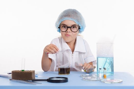 Girl sitting in chemistry class and makes the simplest experiments