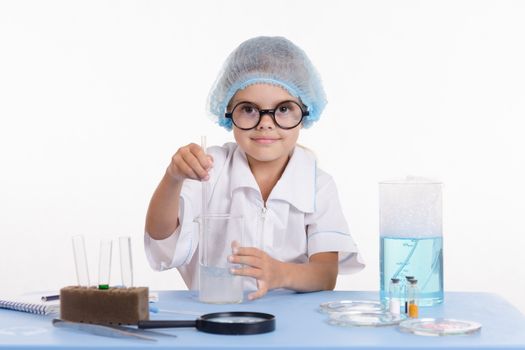 Girl sitting in chemistry class and makes the simplest experiments