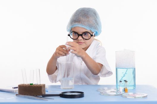Girl sitting in chemistry class and makes the simplest experiments