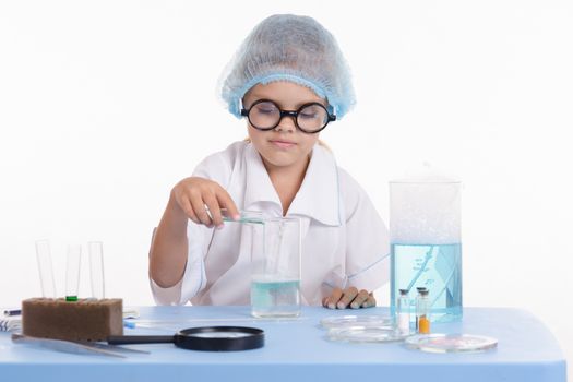 Girl sitting in chemistry class and makes the simplest experiments