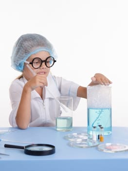 Girl sitting in chemistry class and makes the simplest experiments