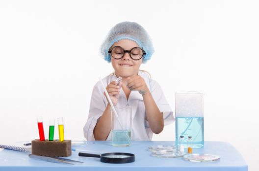 Girl sitting in chemistry class and makes the simplest experiments