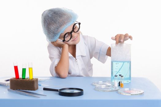 Girl sitting in chemistry class and makes the simplest experiments