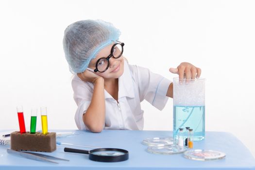 Girl sitting in chemistry class and makes the simplest experiments