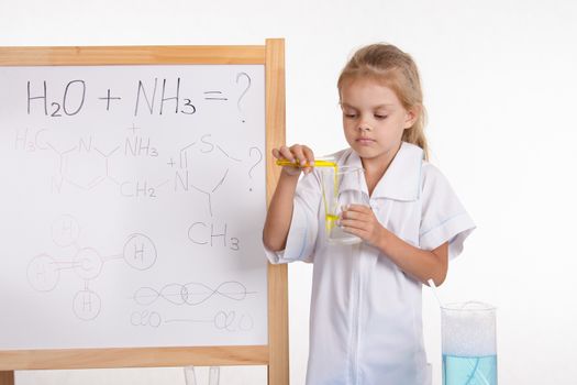 Five-year girl chemist standing at an easel in a bathrobe