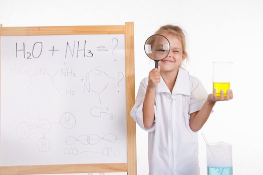 Five-year girl chemist standing at an easel in a bathrobe